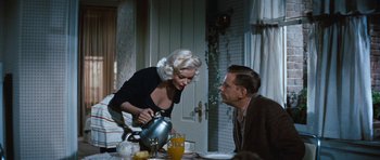 Movie still from “The Girl Can't Help It” (1956), directed by Frank Tashlin – A woman pouring a man a cup of orange juice into his mouth; Medium shot, Over the shoulder angle