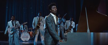 Movie still from “The Girl Can't Help It” (1956), directed by Frank Tashlin – A group of men in suits playing musical instruments on a stage; Medium shot, Low angle