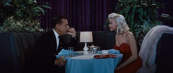 Movie still from “The Girl Can't Help It” (1956), directed by Frank Tashlin – A man and a woman sitting at a dinner table; Medium shot, Over the shoulder angle