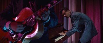 Movie still from “The Girl Can't Help It” (1956), directed by Frank Tashlin – A man playing the piano while a guitar plays; Medium shot, High angle