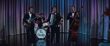 Movie still from “The Girl Can't Help It” (1956), directed by Frank Tashlin – A group of men in tuxedos performing on stage; Wide shot, High angle