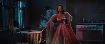 Movie still from “The Girl Can't Help It” (1956), directed by Frank Tashlin – A woman in a pink dress and a fur coat; Medium shot, Low angle