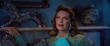 Movie still from “The Girl Can't Help It” (1956), directed by Frank Tashlin – A woman in a blue dress is sitting in front of a mirror; Close Up shot, Low angle