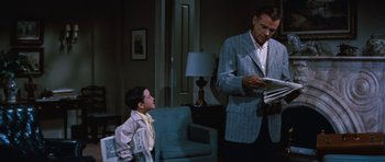 Movie still from “The Girl Can't Help It” (1956), directed by Frank Tashlin – A man and a boy are looking at a piece of paper; Medium shot, Low angle