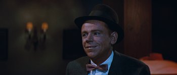 Movie still from “The Girl Can't Help It” (1956), directed by Frank Tashlin – A person wearing a suit and a bow tie; Close Up shot, Over the shoulder angle