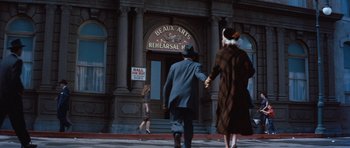 Movie still from “The Girl Can't Help It” (1956), directed by Frank Tashlin – A man and a woman walking down a street; Wide shot, Low angle