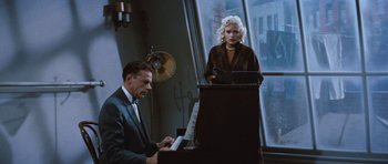 Movie still from “The Girl Can't Help It” (1956), directed by Frank Tashlin – A man and a woman are playing piano in a room; Medium shot, High angle