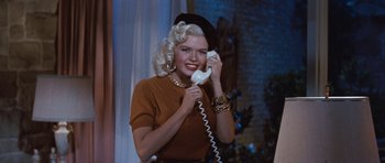 Movie still from “The Girl Can't Help It” (1956), directed by Frank Tashlin – A woman talking on a phone while wearing a hat; Medium shot, Low angle