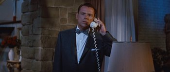 Movie still from “The Girl Can't Help It” (1956), directed by Frank Tashlin – A man in a suit and bow tie holding a phone to his ear; Close Up shot, Low angle