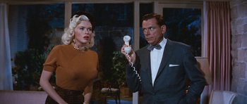 Movie still from “The Girl Can't Help It” (1956), directed by Frank Tashlin – A man and a woman are holding a remote control; Medium shot, Over the shoulder angle