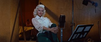 Movie still from “The Girl Can't Help It” (1956), directed by Frank Tashlin – A woman sitting in front of an old fashioned hair dryer; Medium shot, Low angle
