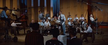 Movie still from “The Girl Can't Help It” (1956), directed by Frank Tashlin – A group of men in suits and ties playing musical instruments in front of an audience; Wide shot, High angle