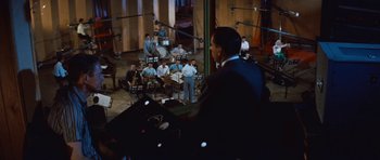 Movie still from “The Girl Can't Help It” (1956), directed by Frank Tashlin – A group of men sitting in a room with microphones; Extreme Wide shot, High angle