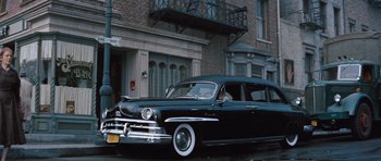 Movie still from “The Girl Can't Help It” (1956), directed by Frank Tashlin – An old car parked on the side of the street; Wide shot, Low angle