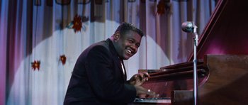 Movie still from “The Girl Can't Help It” (1956), directed by Frank Tashlin – A man sitting at a piano smiling for the camera; Medium shot, Low angle