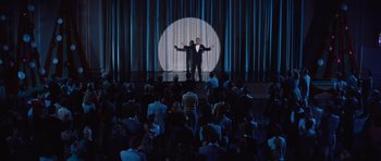 Movie still from “The Girl Can't Help It” (1956), directed by Frank Tashlin – A man standing on a stage in front of an audience; Extreme Wide shot, High angle