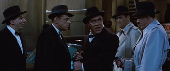 Movie still from “The Girl Can't Help It” (1956), directed by Frank Tashlin – A group of men standing next to each other wearing hats; Medium shot, Over the shoulder angle