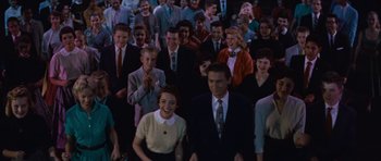 Movie still from “The Girl Can't Help It” (1956), directed by Frank Tashlin – A large group of people standing together in a room; Medium shot, High angle