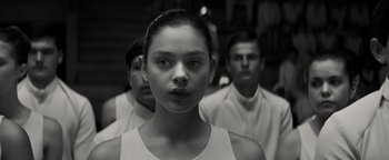 Movie still from “The Giver” (2014), directed by Phillip Noyce – A woman standing in front of two other men; Close Up shot, Over the shoulder angle