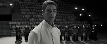 Movie still from “The Giver” (2014), directed by Phillip Noyce – A young man in a white shirt is in front of a group of people; Close Up shot, Low angle