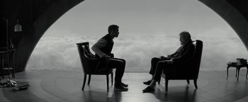 Movie still from “The Giver” (2014), directed by Phillip Noyce – A man and a woman sitting on a chair in front of clouds; Wide shot, Over the shoulder angle