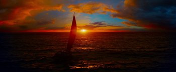 Movie still from “The Giver” (2014), directed by Phillip Noyce – A sailboat in the middle of the ocean at sunset; Extreme Wide shot, Low angle