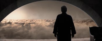 Movie still from “The Giver” (2014), directed by Phillip Noyce – A man standing in front of a cloud filled sky; Wide shot, Low angle
