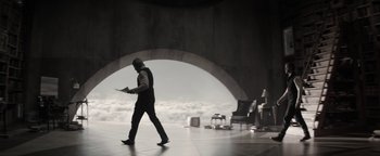 Movie still from “The Giver” (2014), directed by Phillip Noyce – A man in a suit and tie walking through a tunnel; Wide shot, Low angle