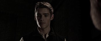 Movie still from “The Giver” (2014), directed by Phillip Noyce – A young man in a black shirt is looking at the camera; Close Up shot, Over the shoulder angle