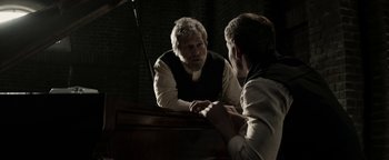 Movie still from “The Giver” (2014), directed by Phillip Noyce – An older man looking at a younger man in the mirror; Medium shot, Over the shoulder angle
