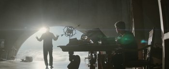 Movie still from “The Giver” (2014), directed by Phillip Noyce – A man standing in front of a table with an object on top of it; Wide shot, Low angle