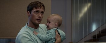 Movie still from “The Giver” (2014), directed by Phillip Noyce – A man holding a crying baby in his arms; Close Up shot, Over the shoulder angle