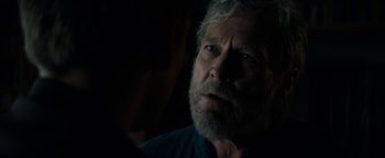 Movie still from “The Giver” (2014), directed by Phillip Noyce – A person with a beard looking at the camera; Close Up shot, Over the shoulder angle