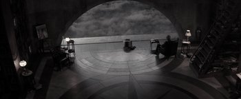 Movie still from “The Giver” (2014), directed by Phillip Noyce – A person sitting on a chair in a circle of clouds; Extreme Wide shot, High angle