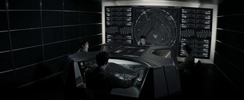 Movie still from “The Giver” (2014), directed by Phillip Noyce – Three men are in a room with a map on the wall behind them; Wide shot, High angle