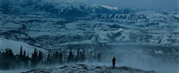 Movie still from “The Giver” (2014), directed by Phillip Noyce – A person standing on top of a hill in the snow; Extreme Wide shot, High angle