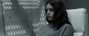 Movie still from “The Giver” (2014), directed by Phillip Noyce – A young woman with long dark brown hair stares into the camera; Medium shot, Low angle