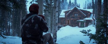 Movie still from “The Giver” (2014), directed by Phillip Noyce – A person sitting in the snow near a house; Wide shot, Low angle