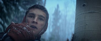 Movie still from “The Giver” (2014), directed by Phillip Noyce – A young man in a hooded jacket looking into the distance; Close Up shot, Low angle