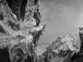 Movie still from “The Gold Rush” (1925), directed by Charles Chaplin – A man standing on top of a mountain; Extreme Wide shot, High angle