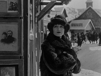 Movie still from “The Gold Rush” (1925), directed by Charles Chaplin – An old photo of a woman standing in the snow; Medium shot, Low angle