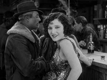 Movie still from “The Gold Rush” (1925), directed by Charles Chaplin – A man and a woman are posing for a picture; Medium shot, Over the shoulder angle