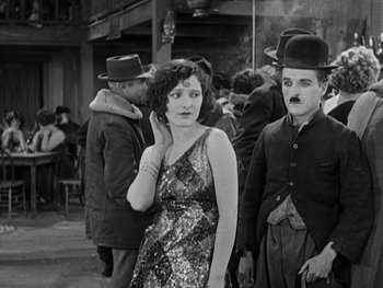 Movie still from “The Gold Rush” (1925), directed by Charles Chaplin – A man and a woman standing next to each other; Medium shot, Over the shoulder angle