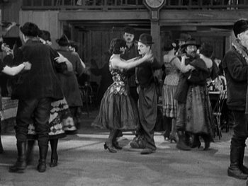 Movie still from “The Gold Rush” (1925), directed by Charles Chaplin – A group of people dancing in a room; Wide shot, High angle