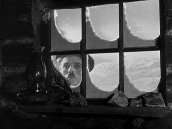 Movie still from “The Gold Rush” (1925), directed by Charles Chaplin – A black and white photo of a man looking out of a window; Close Up shot, Low angle
