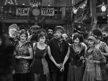 Movie still from “The Gold Rush” (1925), directed by Charles Chaplin – A black and white photo of a group of young people; Medium shot, High angle