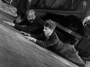 Movie still from “The Gold Rush” (1925), directed by Charles Chaplin – A man and a boy climbing a ramp; Medium shot, High angle