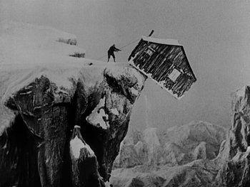 Movie still from “The Gold Rush” (1925), directed by Charles Chaplin – A man standing on top of a snow covered mountain; Extreme Wide shot, Low angle