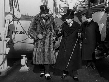 Movie still from “The Gold Rush” (1925), directed by Charles Chaplin – A group of men standing next to each other on a boat; Medium shot, Low angle