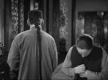 Movie still from “The Good Earth” (1937), directed by Sidney Franklin – A man and a woman standing next to each other in a room; Medium shot, Over the shoulder angle